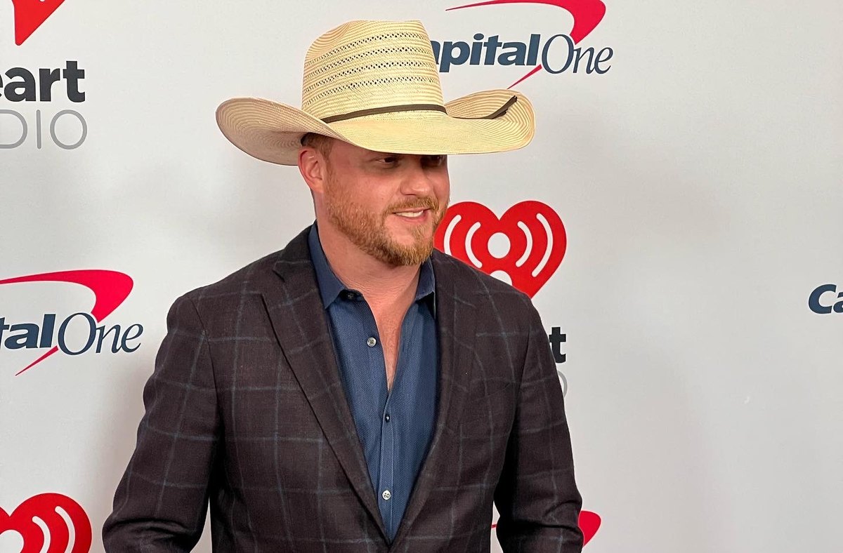 Cody Johnson in a straw hat on the iHeartCountry Festival step-and-repeat.