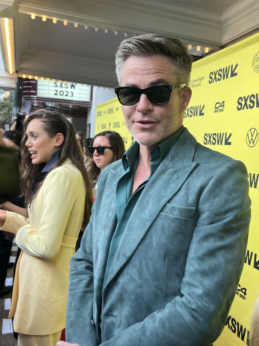 Chris Pine in sunglasses and a grey suit on the SXSW step-and-repeat.
